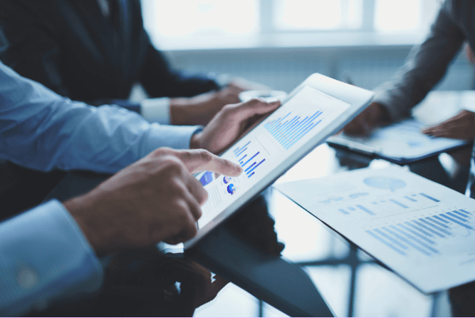 Professionals analyzing digital marketing charts on tablet, PPC agency in Chandigarh