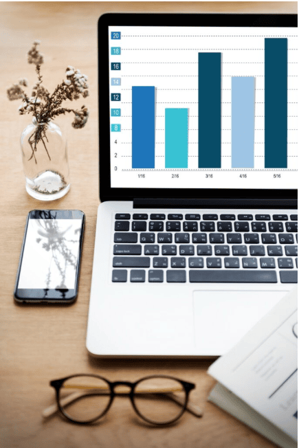 Business performance chart on laptop with branding tools on desk by a business branding agency in Chandigarh.